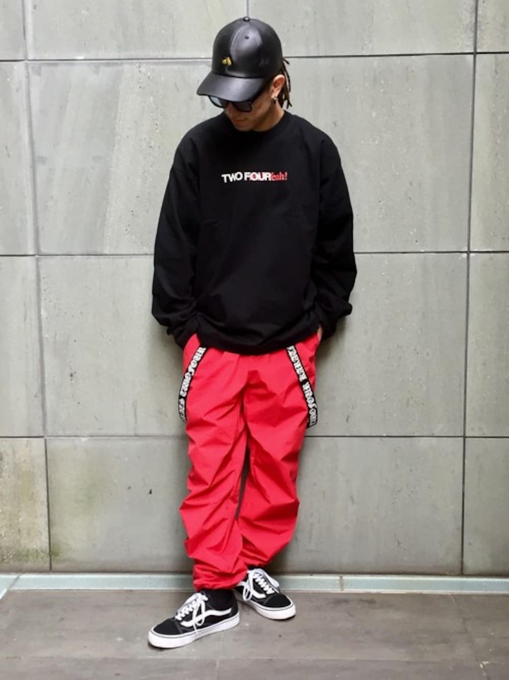 ブラック系のTシャツ/カットソー、レッド系のその他パンツ、ブラック系のキャップを着用したメンズの春コーディネートの1枚目の写真