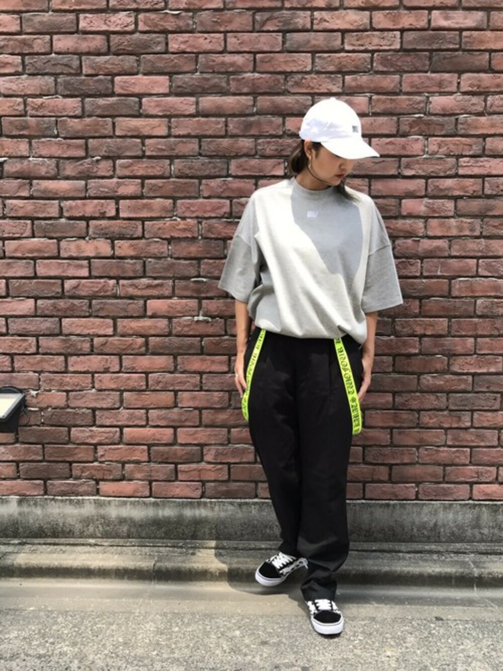 グレー系のTシャツ/カットソー、ホワイト系のキャップ、イエロー系のサスペンダーを着用したレディースの春コーディネートの1枚目の写真