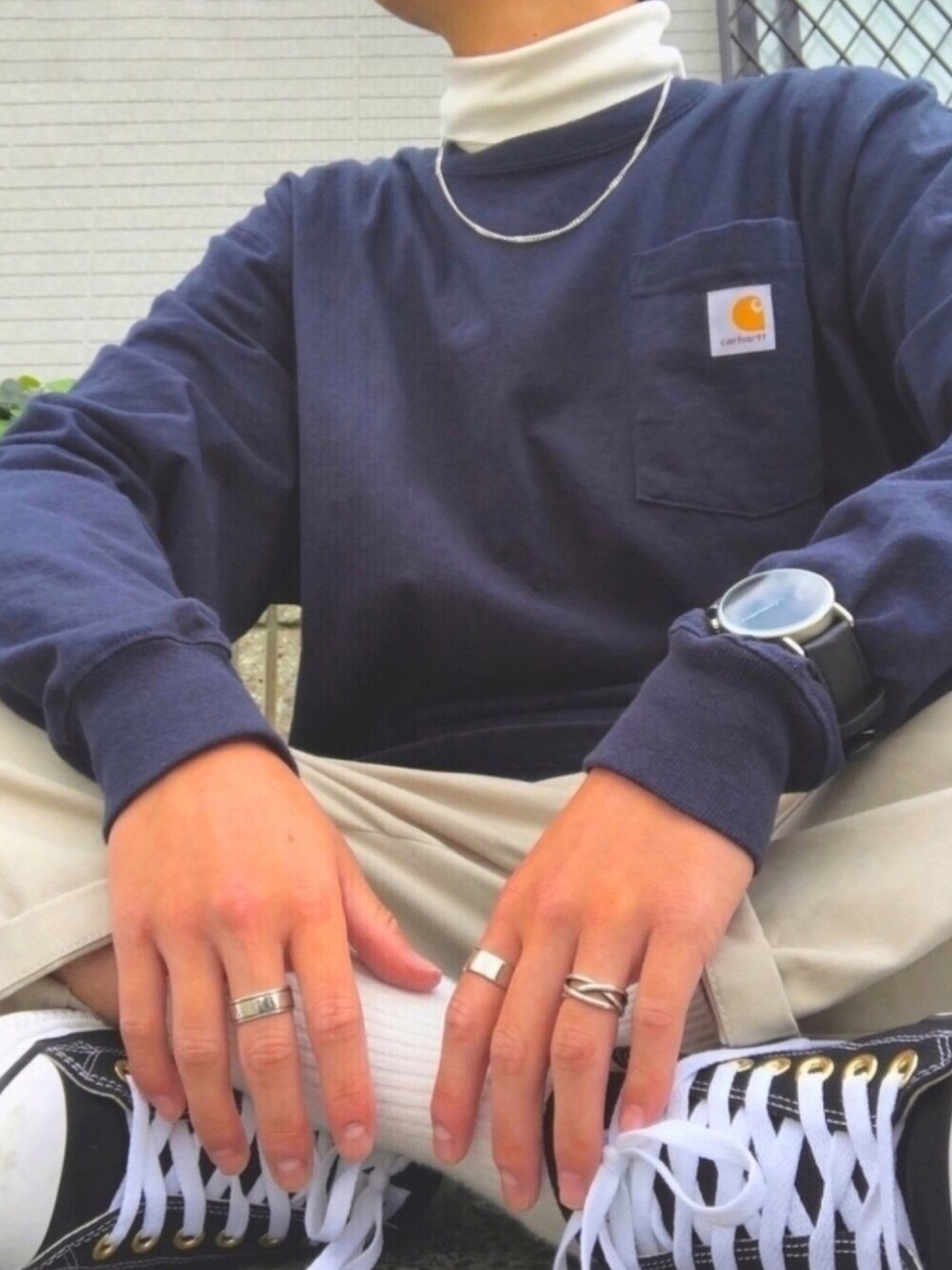 ブルー系のTシャツ/カットソー、ホワイト系のニット/セーター、ブラック系のスニーカーを着用したメンズの春コーディネートの1枚目の写真