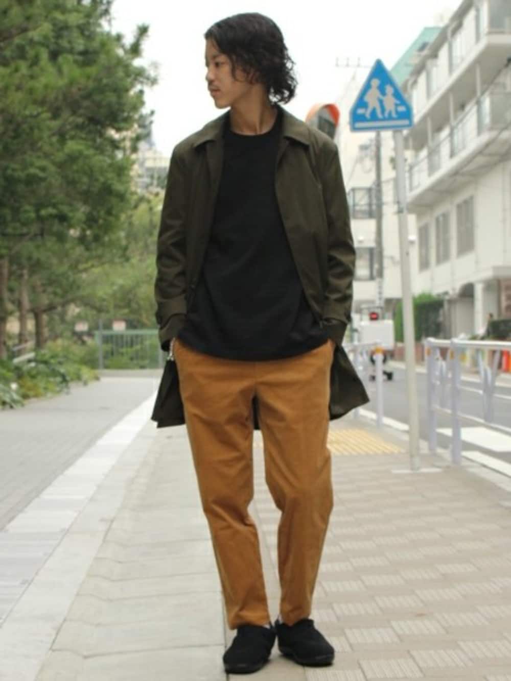グリーン系のステンカラーコート、ブラック系のTシャツ/カットソー、ベージュ系のその他パンツを着用したメンズの秋コーディネートの1枚目の写真
