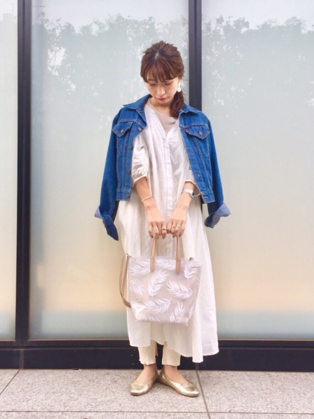 ホワイト系のワンピース、ゴールド系のバレエシューズ、ブルー系のデニムジャケットを着用したレディースの春コーディネートの1枚目の写真