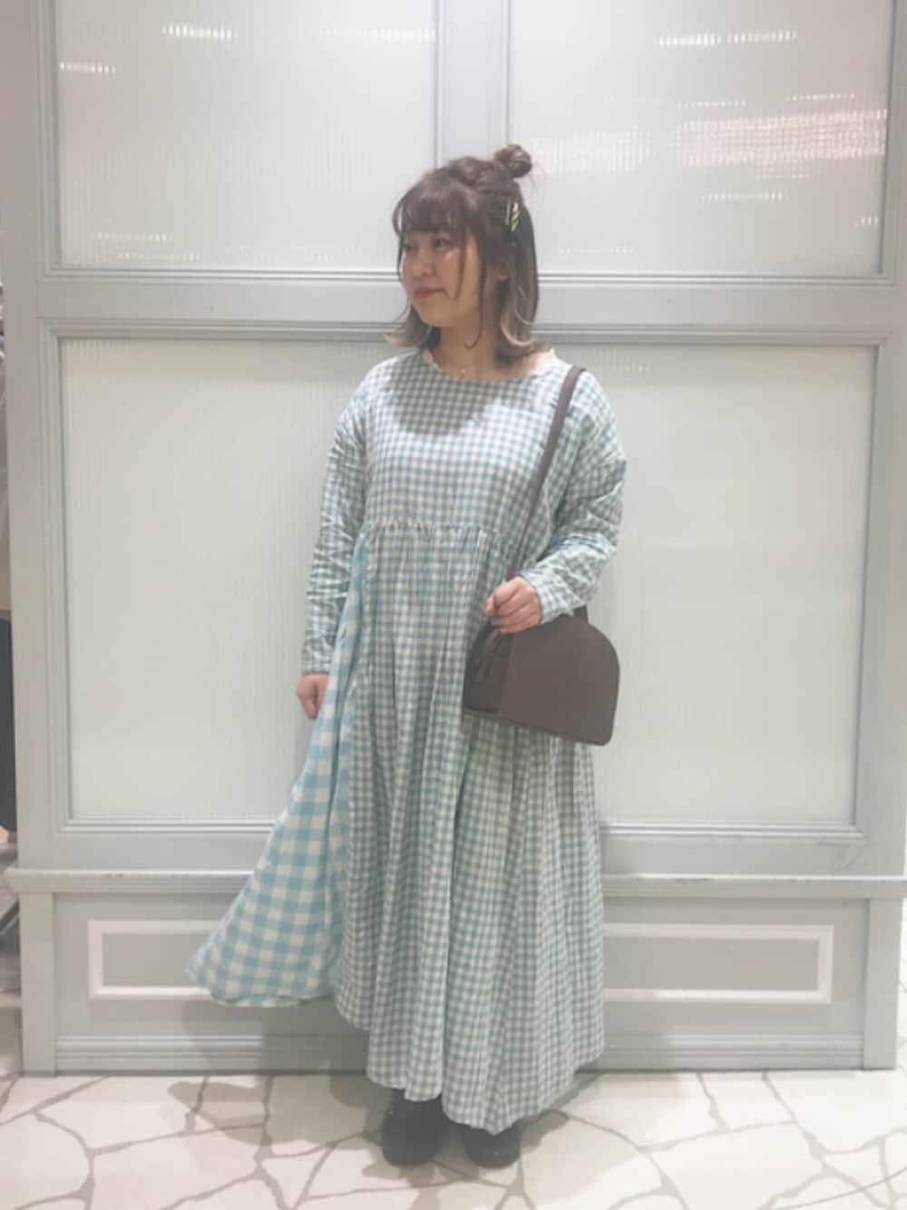 ブルー系のワンピース、ブラウン系のショルダーバッグ、ホワイト系のTシャツ/カットソーを着用したレディースの冬コーディネートの1枚目の写真
