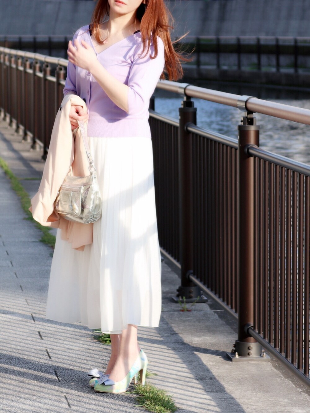 パープル系のニット/セーター、ホワイト系のスカート、その他のパンプスを着用したレディースの春コーディネートの1枚目の写真
