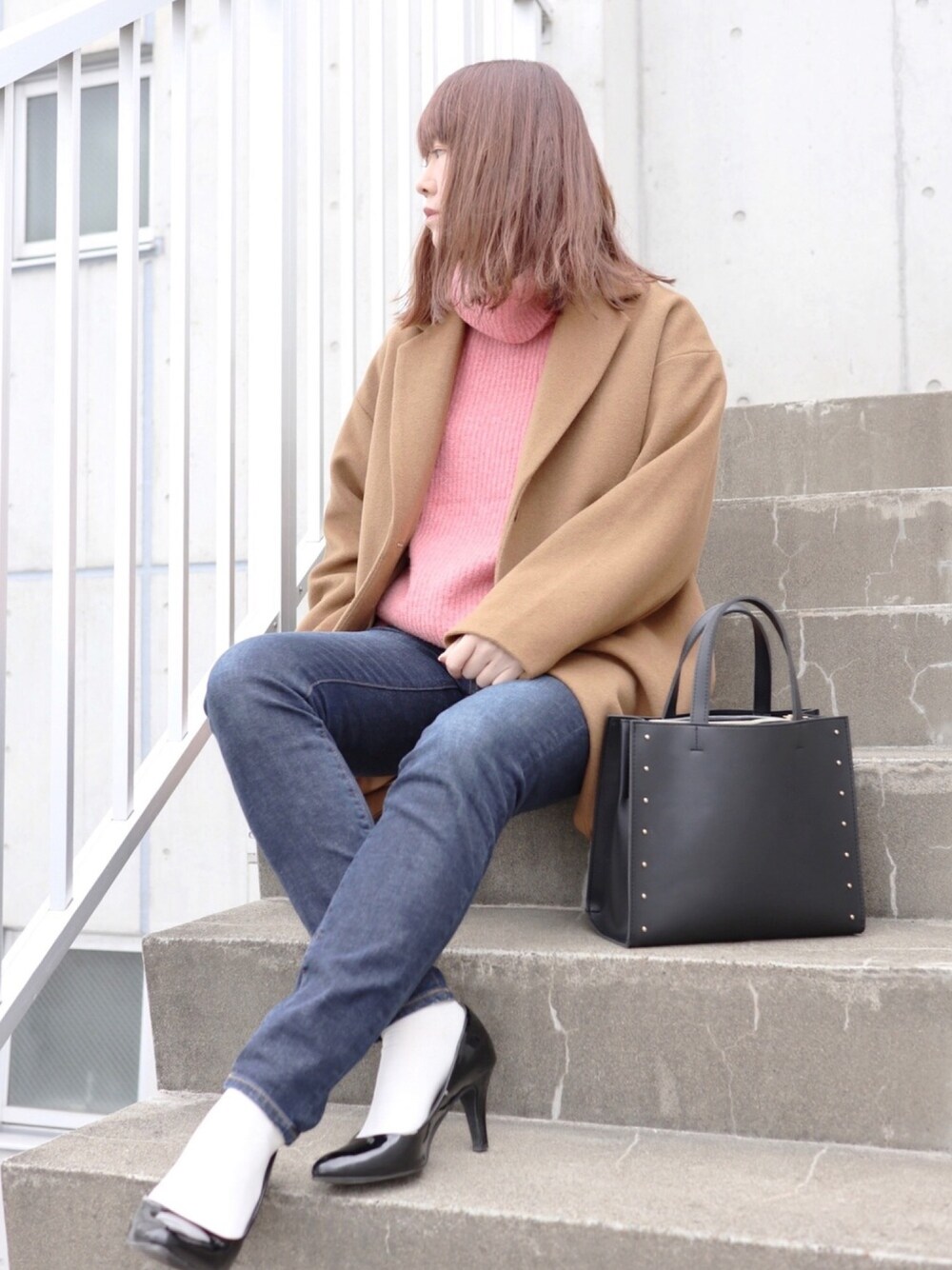 ピンク系のニット/セーター、ブルー系のデニムパンツ、ブラック系のパンプスを着用したレディースの秋コーディネートの1枚目の写真