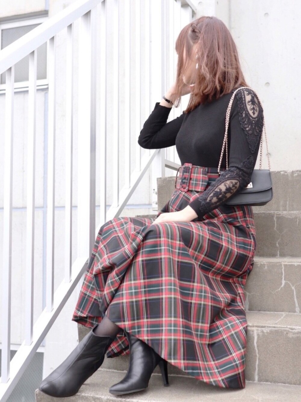 ブラック系のニット/セーター、ブラック系のスカート、ブラック系のショルダーバッグを着用したレディースの秋コーディネートの1枚目の写真