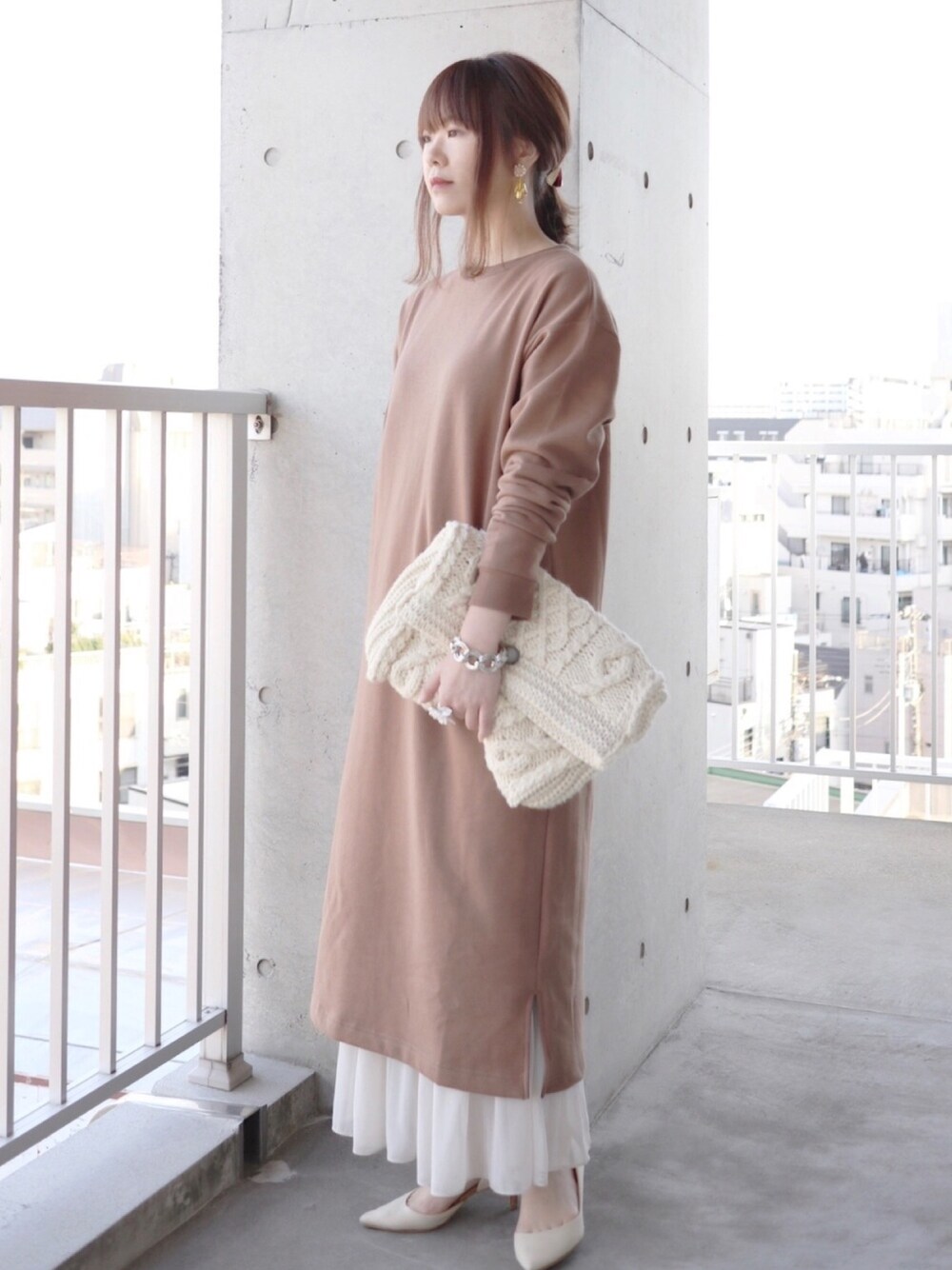 ベージュ系のワンピース、ベージュ系のスカート、ホワイト系のクラッチバッグを着用したレディースの秋コーディネートの1枚目の写真