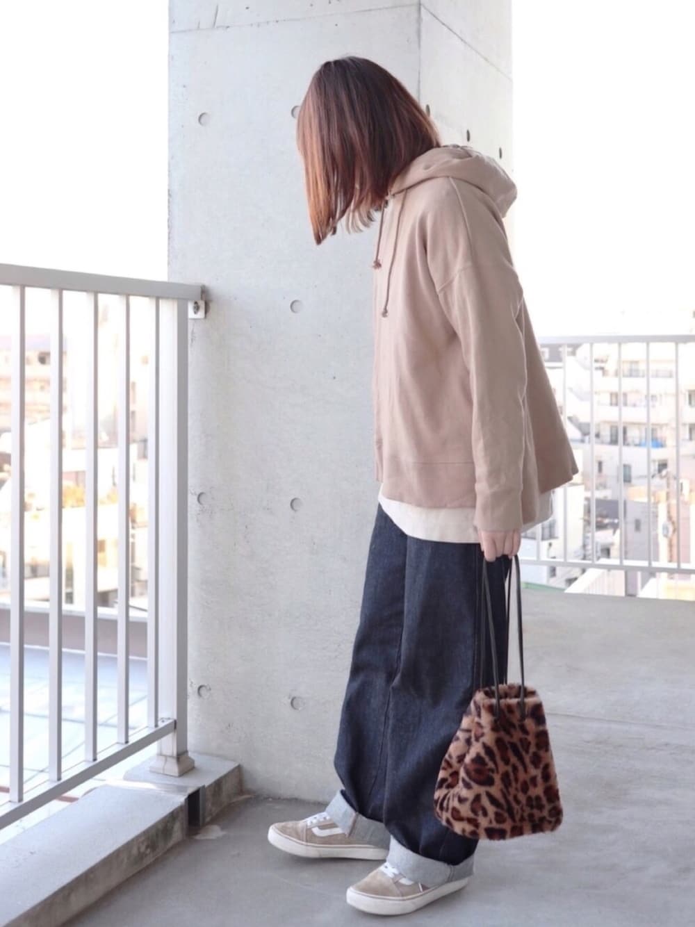 ベージュ系のスウェット、ベージュ系のTシャツ/カットソー、ブルー系のデニムパンツを着用したレディースの冬コーディネートの1枚目の写真
