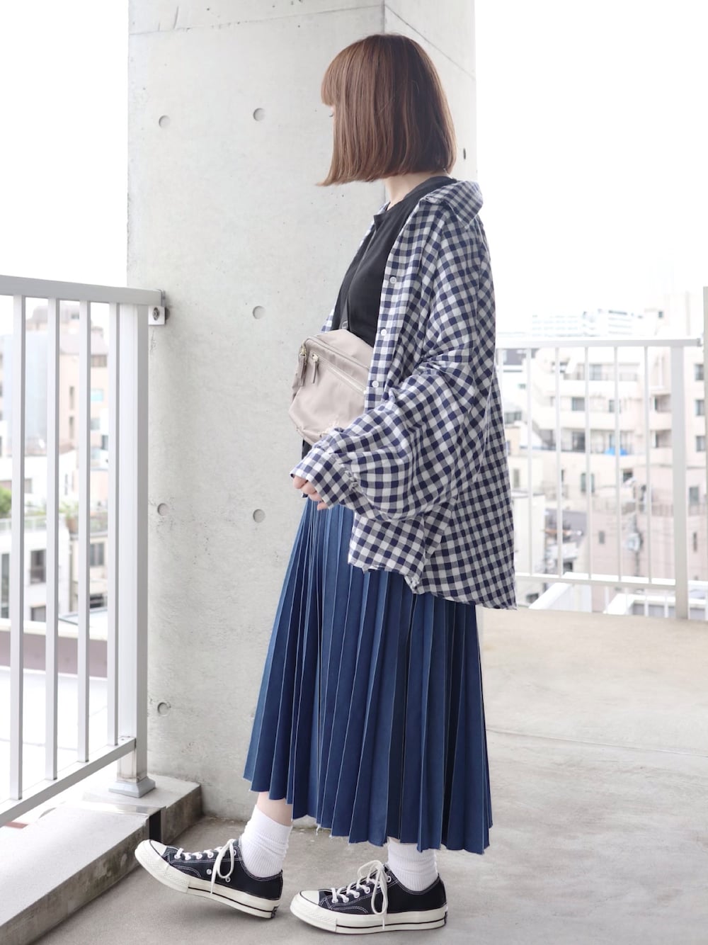 ブラック系のTシャツ/カットソー、グレー系のショルダーバッグ、ブルー系のデニムスカートを着用したレディースの春コーディネートの1枚目の写真