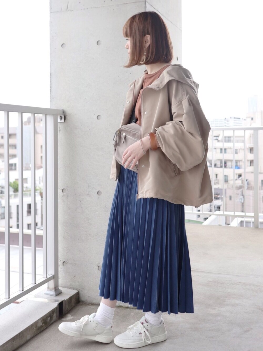 ブルー系のデニムスカート、ブラウン系のTシャツ/カットソー、グレー系のショルダーバッグを着用したレディースの春コーディネートの1枚目の写真