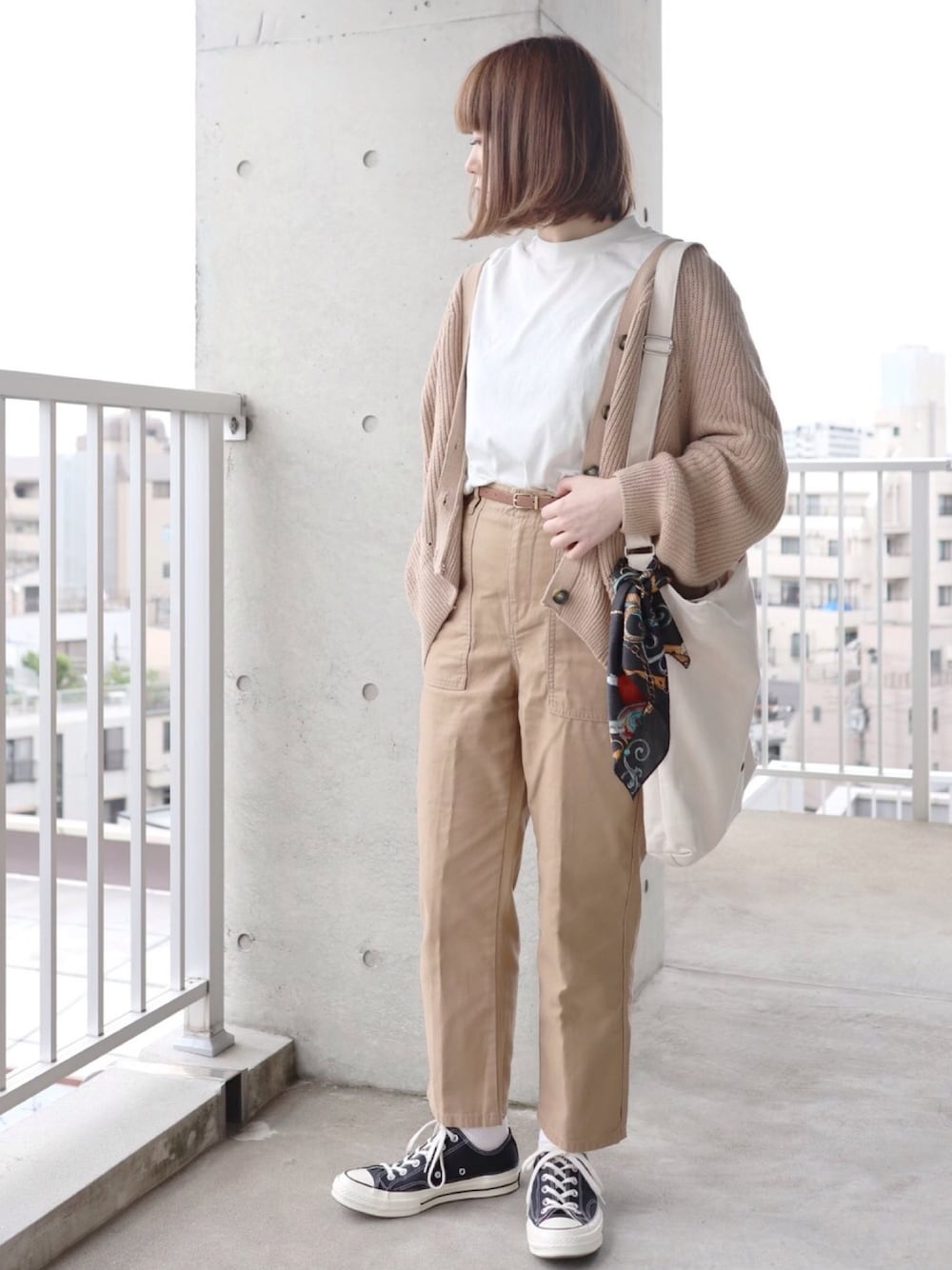 ベージュ系のカーディガン/ボレロ、ホワイト系のTシャツ/カットソー、ホワイト系のトートバッグを着用したレディースの春コーディネートの1枚目の写真