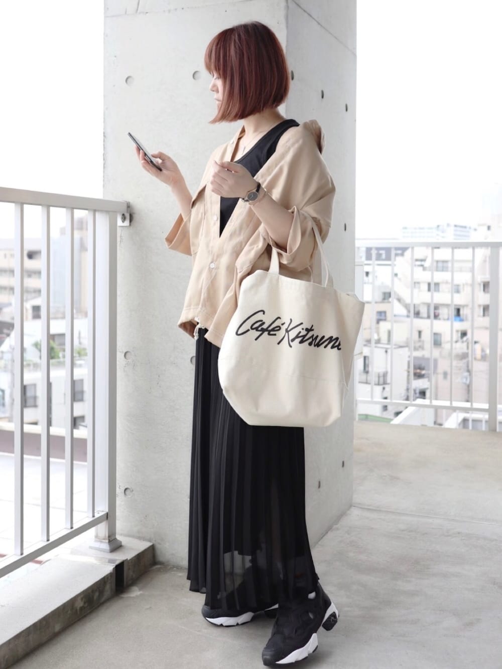 ベージュ系のシャツ/ブラウス、ブラック系のスカート、ブラック系のスニーカーを着用したレディースの夏コーディネートの1枚目の写真