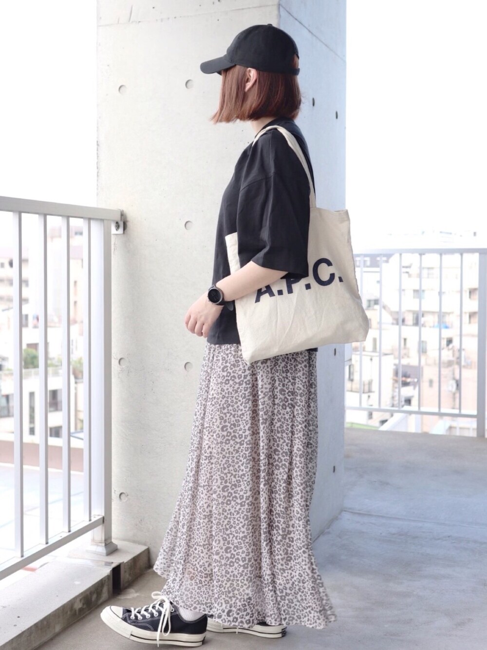 ブラック系のTシャツ/カットソー、ホワイト系のスカート、ブラック系のスニーカーを着用したレディースの夏コーディネートの1枚目の写真