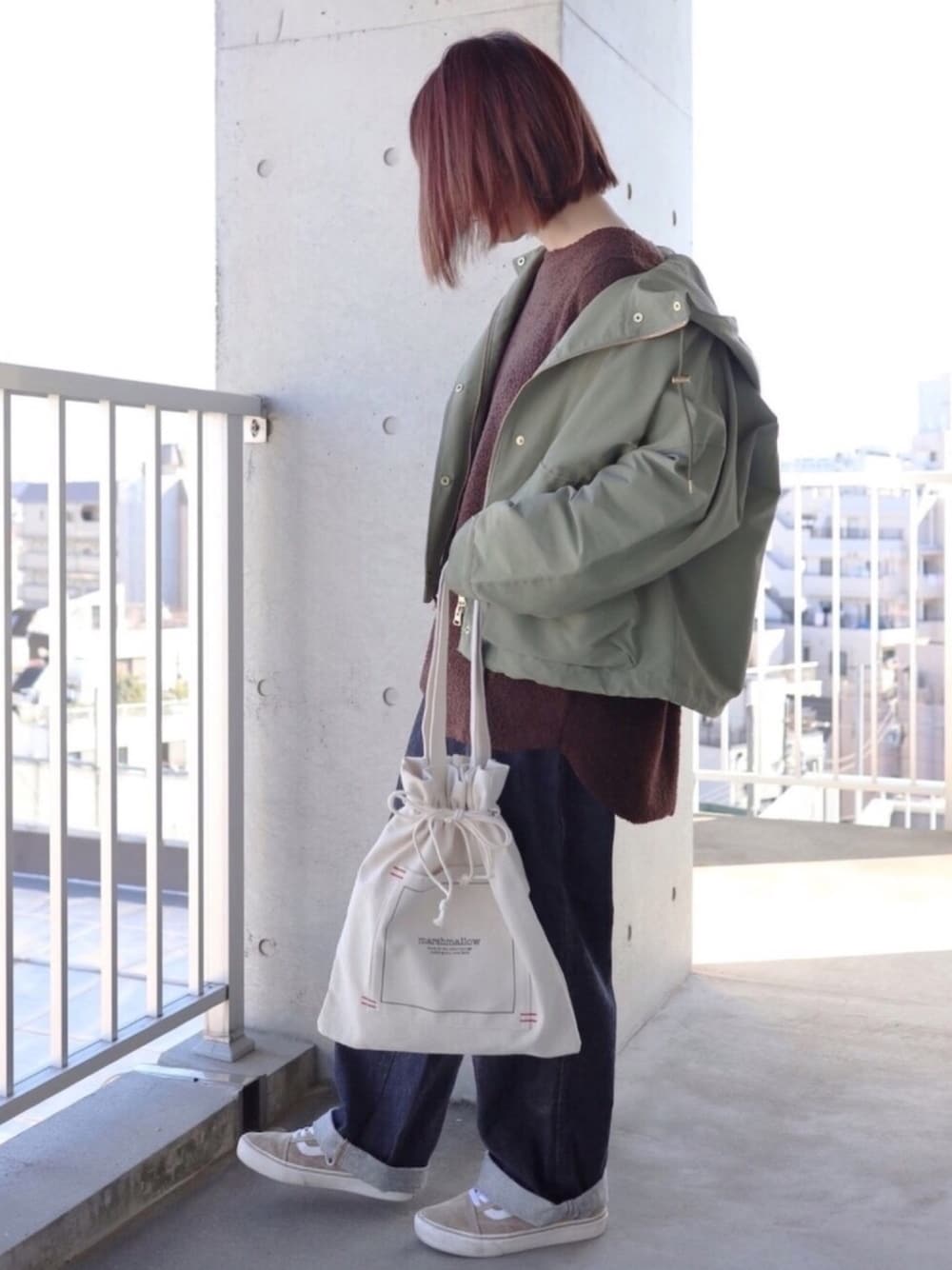 ブラウン系のTシャツ/カットソー、ベージュ系のトートバッグ、グリーン系のマウンテンパーカーを着用したレディースの秋コーディネートの1枚目の写真