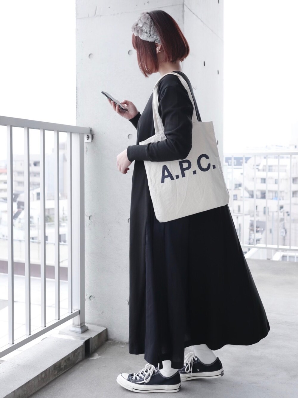 ブラック系のワンピース、ブラック系のスニーカー、その他のイヤーカフを着用したレディースの冬コーディネートの1枚目の写真