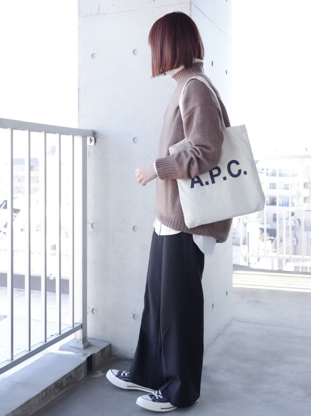 ベージュ系のニット/セーター、ホワイト系のシャツ/ブラウス、ブラック系のスラックスを着用したレディースの冬コーディネートの1枚目の写真