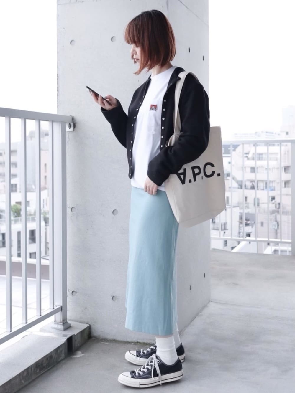 ホワイト系のTシャツ/カットソー、ブラック系のカーディガン/ボレロ、ブルー系のスカートを着用したレディースの春コーディネートの1枚目の写真