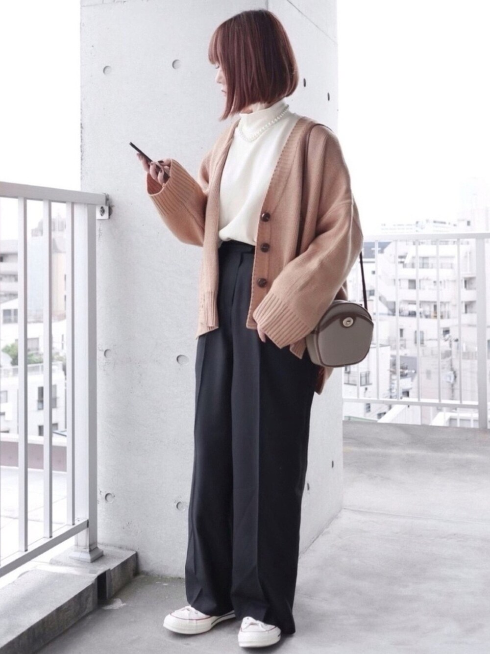 ベージュ系のカーディガン/ボレロ、ブラック系のスラックス、ホワイト系のTシャツ/カットソーを着用したレディースの秋コーディネートの1枚目の写真