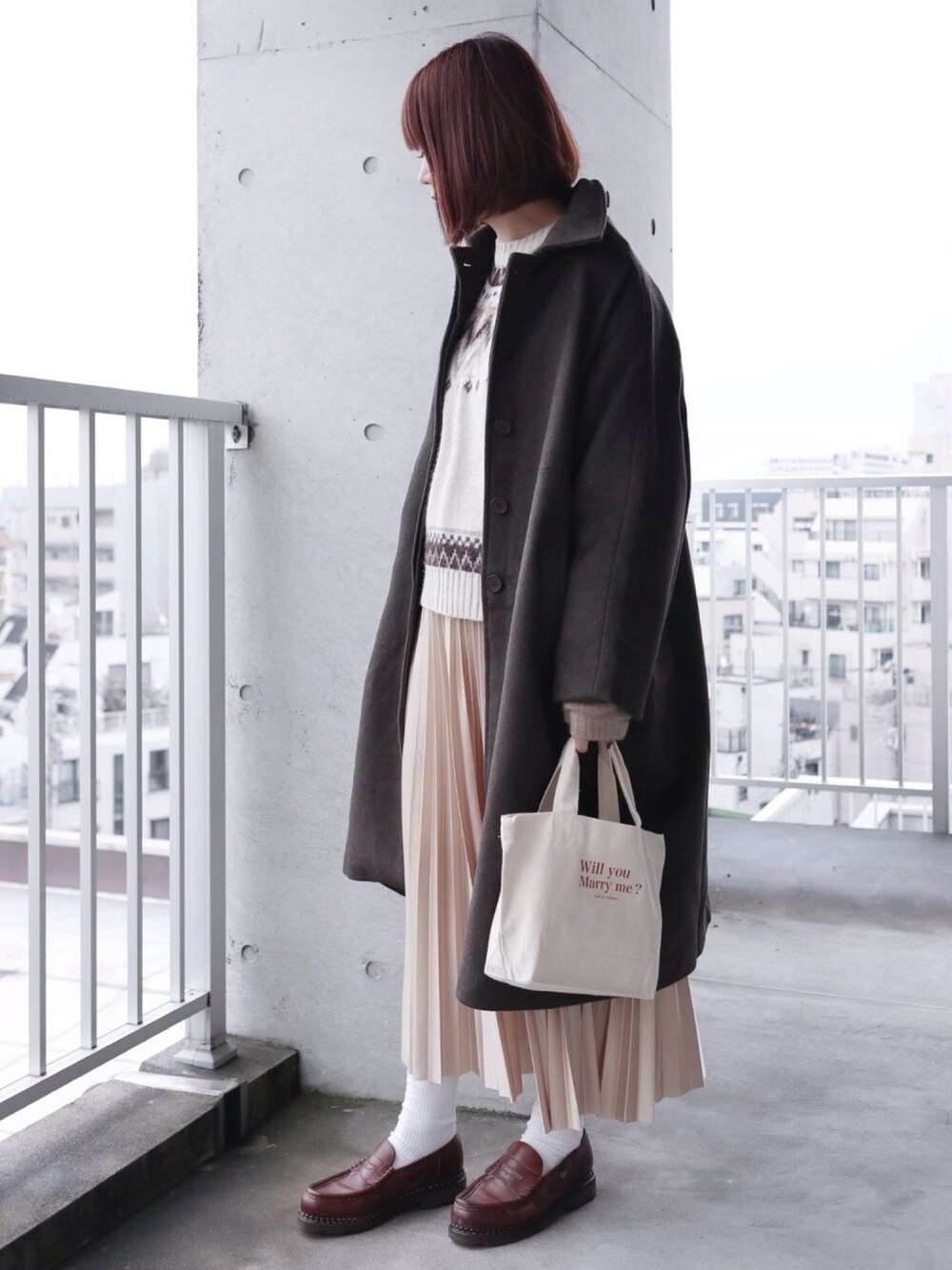 ブラウン系のステンカラーコート、ベージュ系のニット/セーター、ゴールド系のスカートを着用したレディースの冬コーディネートの1枚目の写真