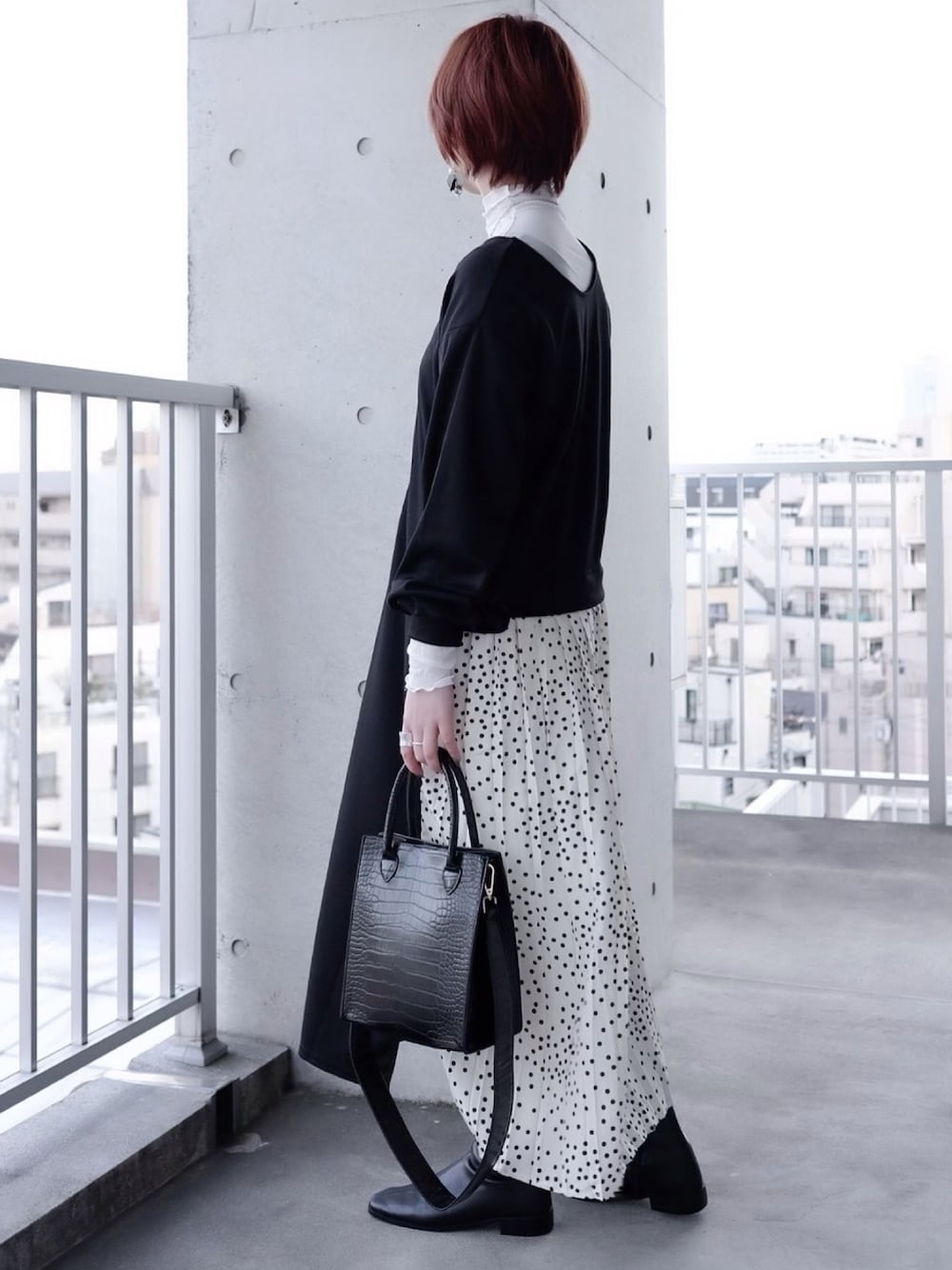 ブラック系のワンピース、ホワイト系のTシャツ/カットソー、ブラック系のハンドバッグを着用したレディースの冬コーディネートの1枚目の写真