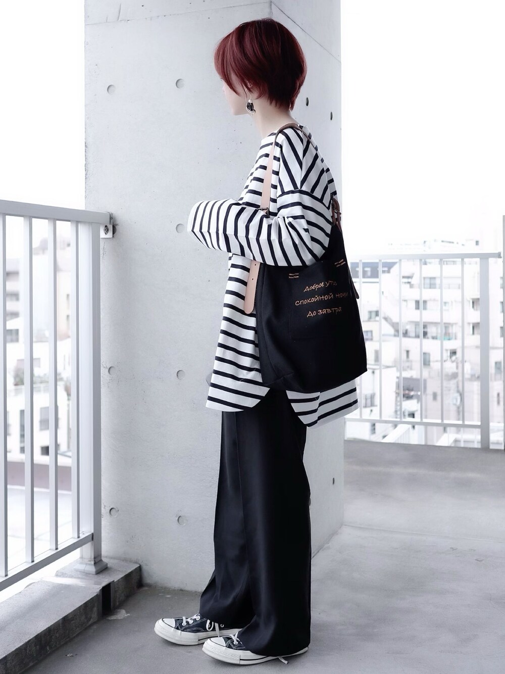 ブルー系のTシャツ/カットソー、ブラック系のスラックス、ブラック系のショルダーバッグを着用したレディースの春コーディネートの1枚目の写真