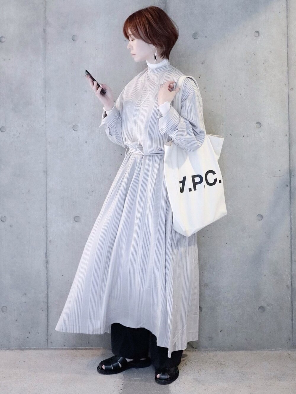 ベージュ系のワンピース、ホワイト系のTシャツ/カットソー、ホワイト系のトートバッグを着用したレディースの春コーディネートの1枚目の写真