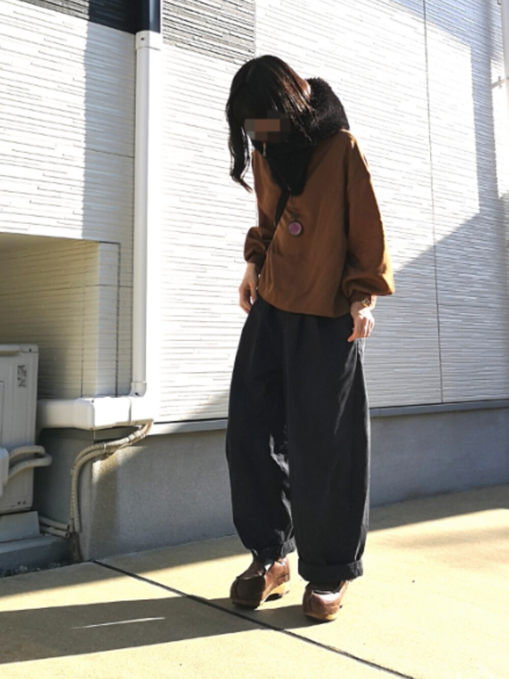 ブラウン系のTシャツ/カットソー、ブルー系のチノパンツ、ブラウン系のスニーカーを着用したレディースの冬コーディネートの1枚目の写真