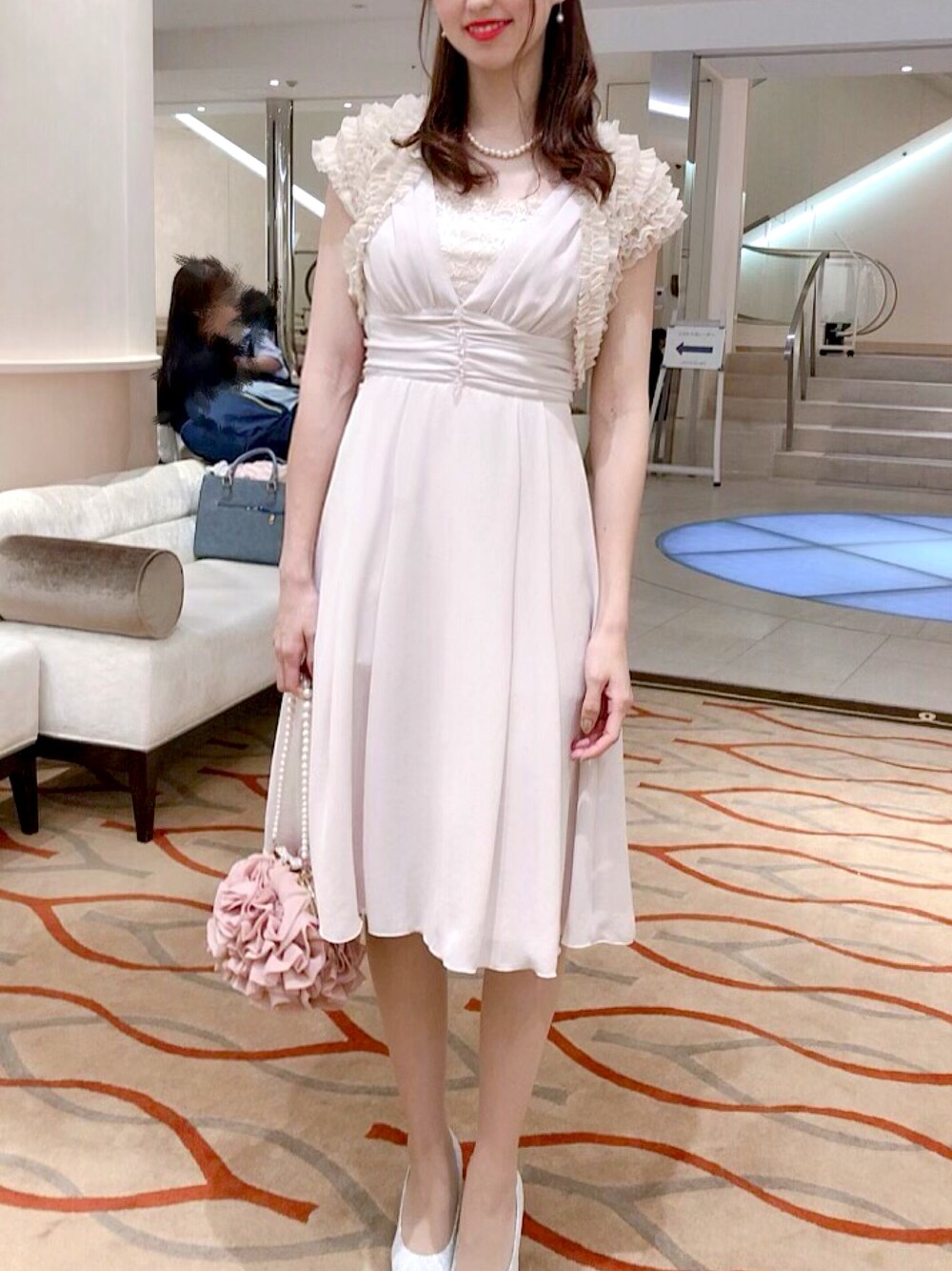 ピンク系のハンドバッグ、ピンク系のドレスを着用したレディースの秋コーディネートの1枚目の写真