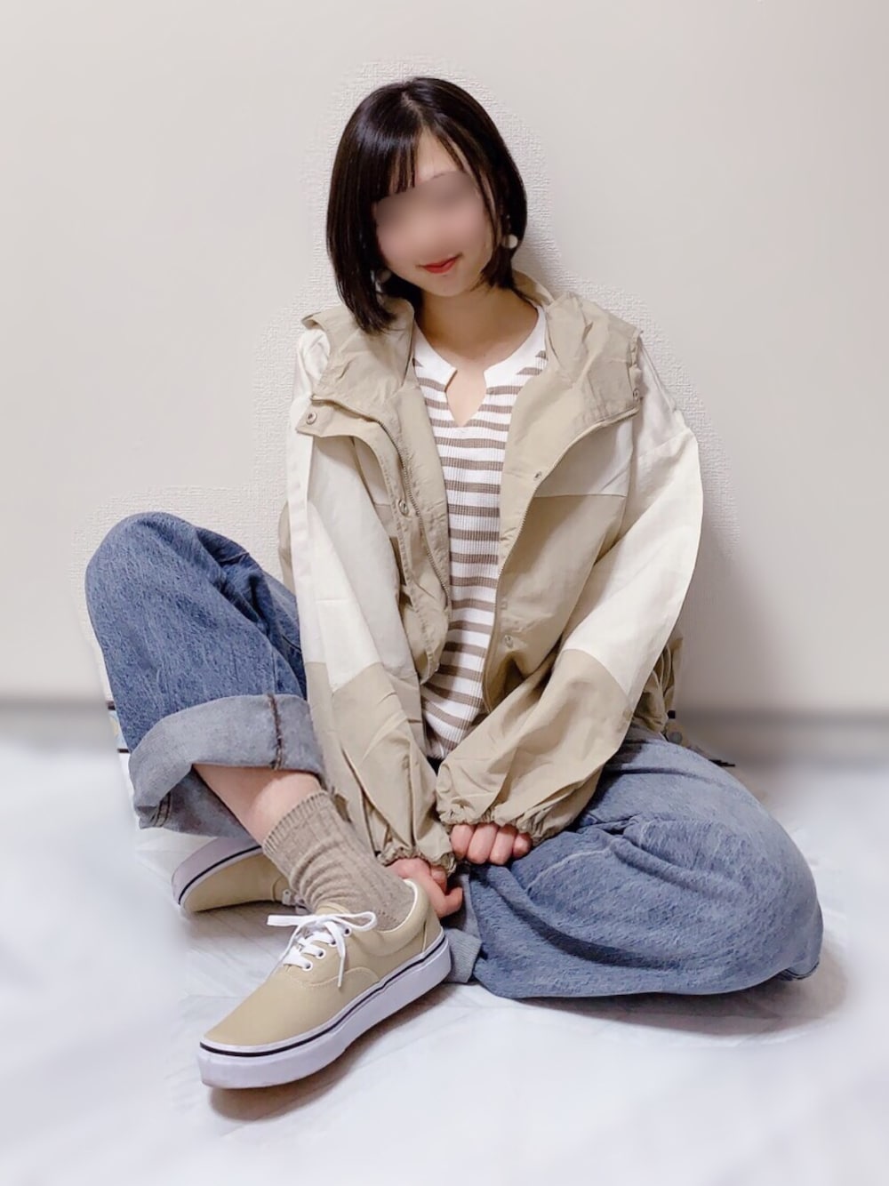 ホワイト系のマウンテンパーカー、ベージュ系のTシャツ/カットソー、ブルー系のデニムパンツを着用したレディースの冬コーディネートの1枚目の写真