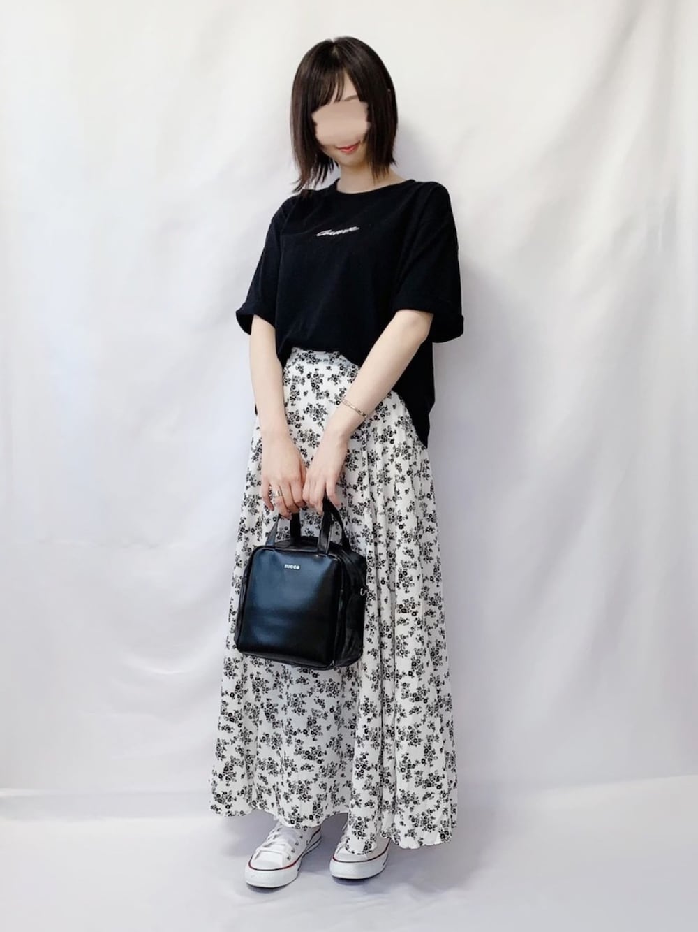ブラック系のTシャツ/カットソー、ホワイト系のスカート、ブラック系のショルダーバッグを着用したレディースの夏コーディネートの1枚目の写真