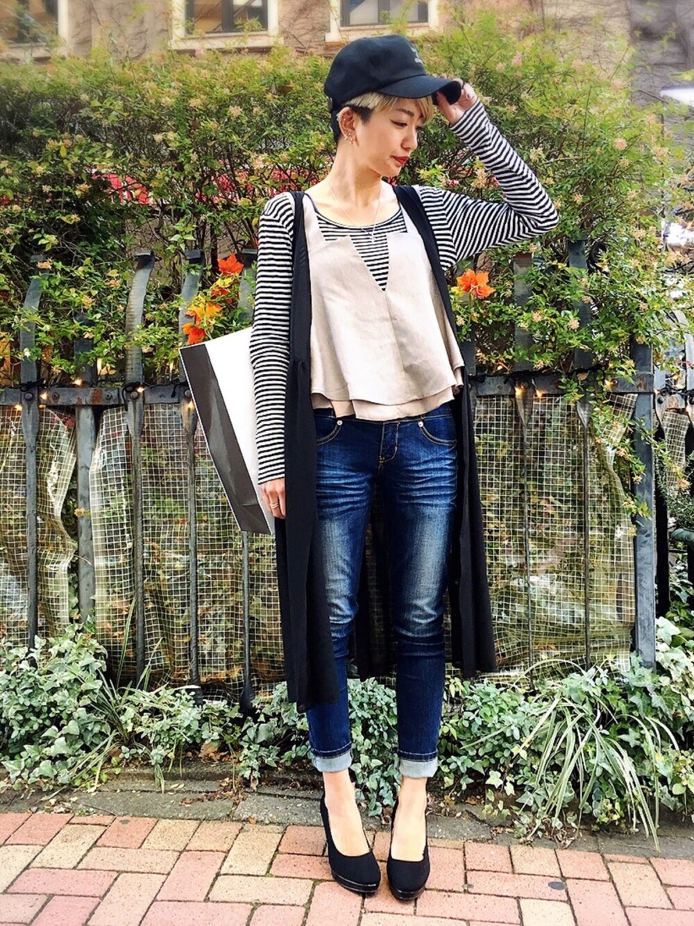 ベージュ系のキャミソール、ブルー系のデニムパンツ、ブラック系のテーラードジャケットを着用したレディースの冬コーディネートの1枚目の写真