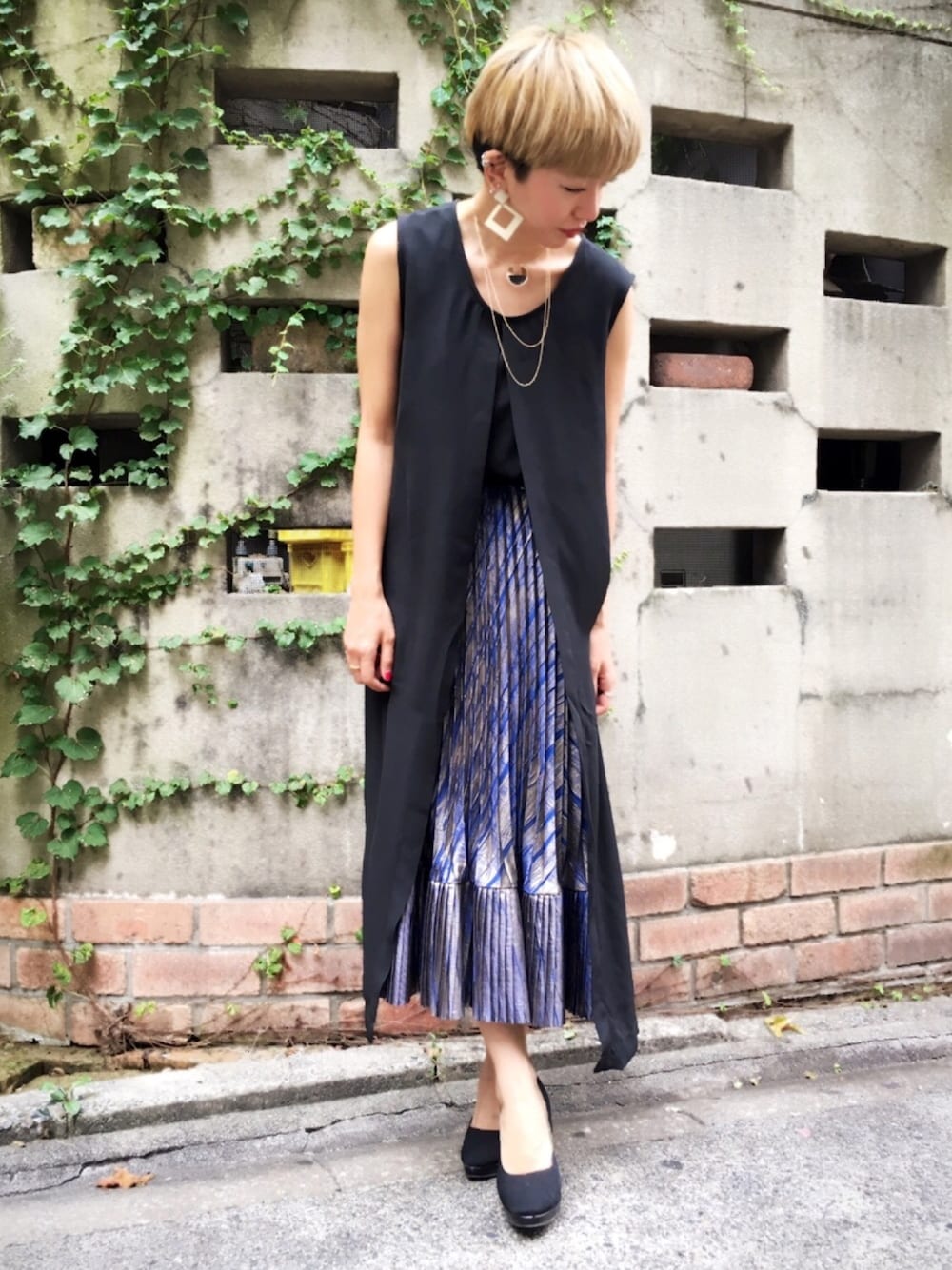 ブラック系のワンピース、ブルー系のスカートを着用したレディースの夏コーディネートの1枚目の写真