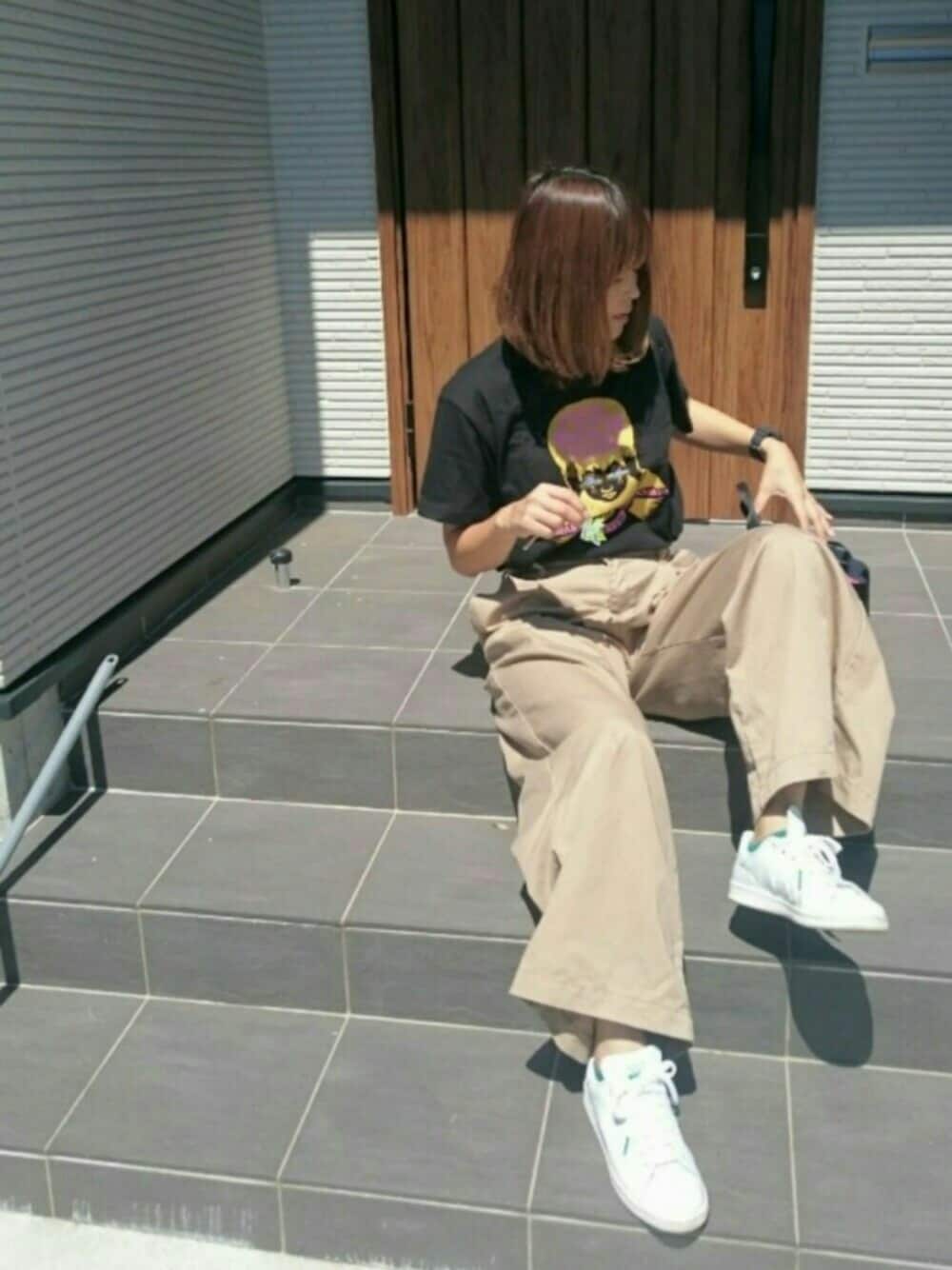 ブラック系のTシャツ/カットソー、ベージュ系のチノパンツ、ホワイト系のスニーカーを着用したレディースの夏コーディネートの1枚目の写真