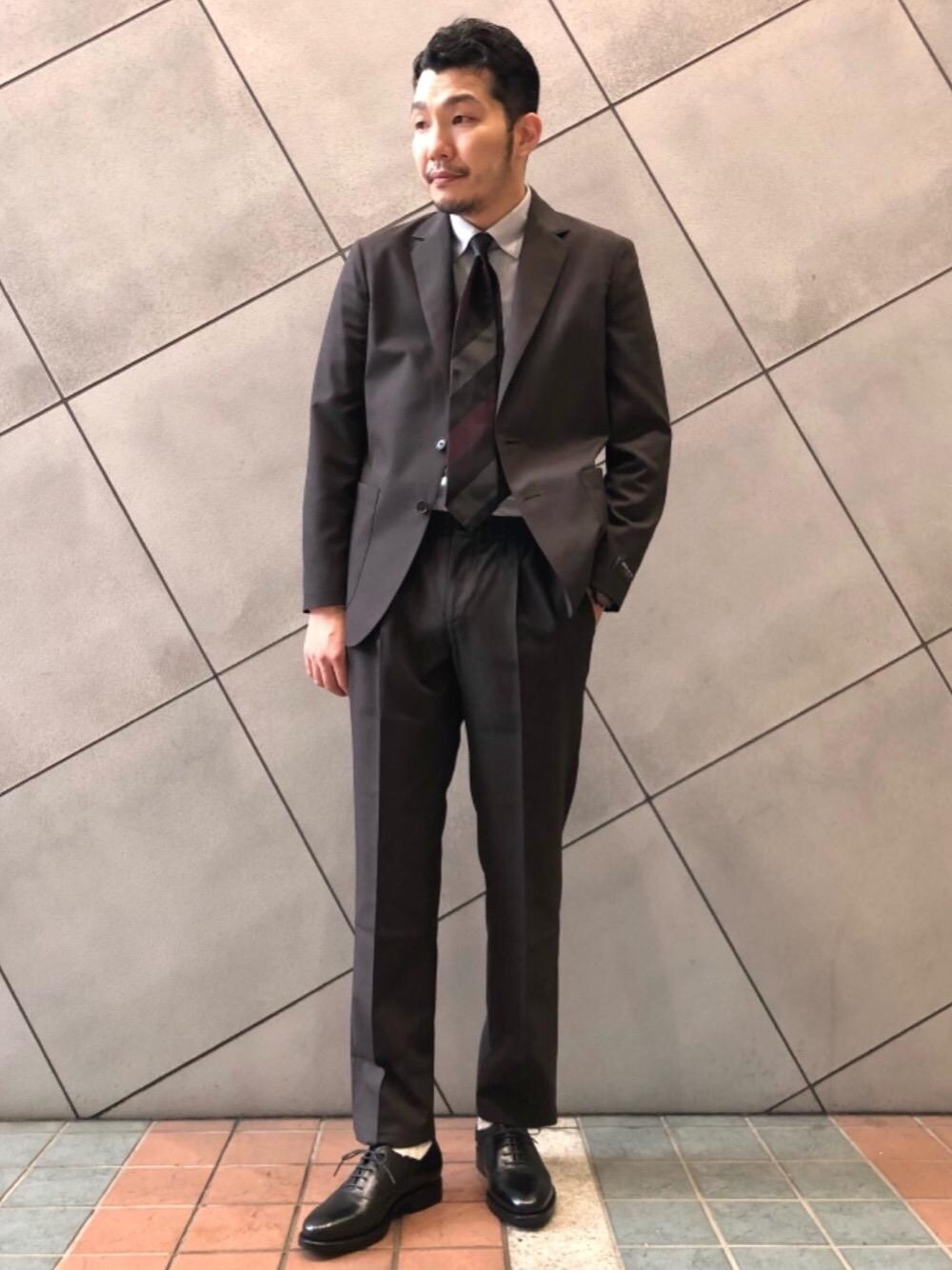 グレー系のシャツ/ブラウス、ブラック系のドレスシューズ、レッド系のネクタイを着用したメンズの夏コーディネートの1枚目の写真