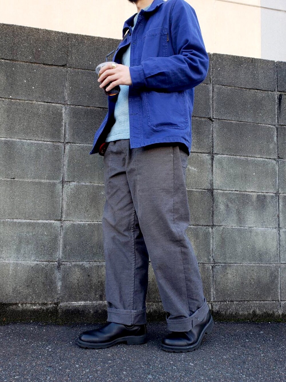 グレー系のパンツ、ブラック系のブーツを着用したメンズの秋コーディネートの1枚目の写真