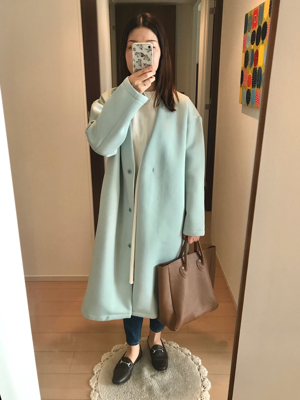 グリーン系のその他アウター、ホワイト系のニット/セーター、ブルー系のデニムパンツを着用したレディースの春コーディネートの1枚目の写真