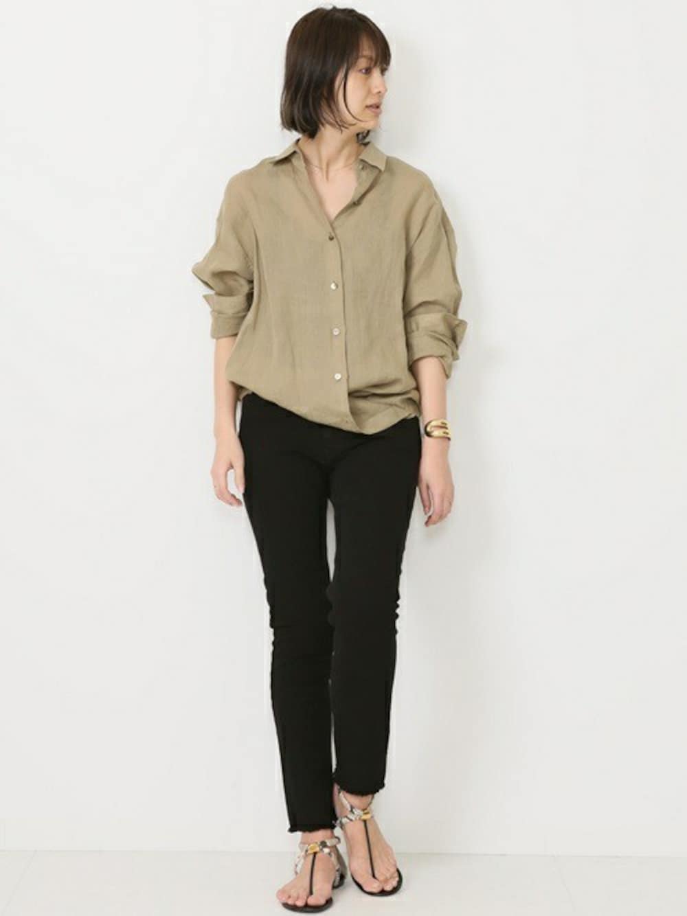 ベージュ系のシャツ/ブラウス、ホワイト系のサンダル、ゴールド系のバングル/リストバンドを着用したレディースの春コーディネートの1枚目の写真