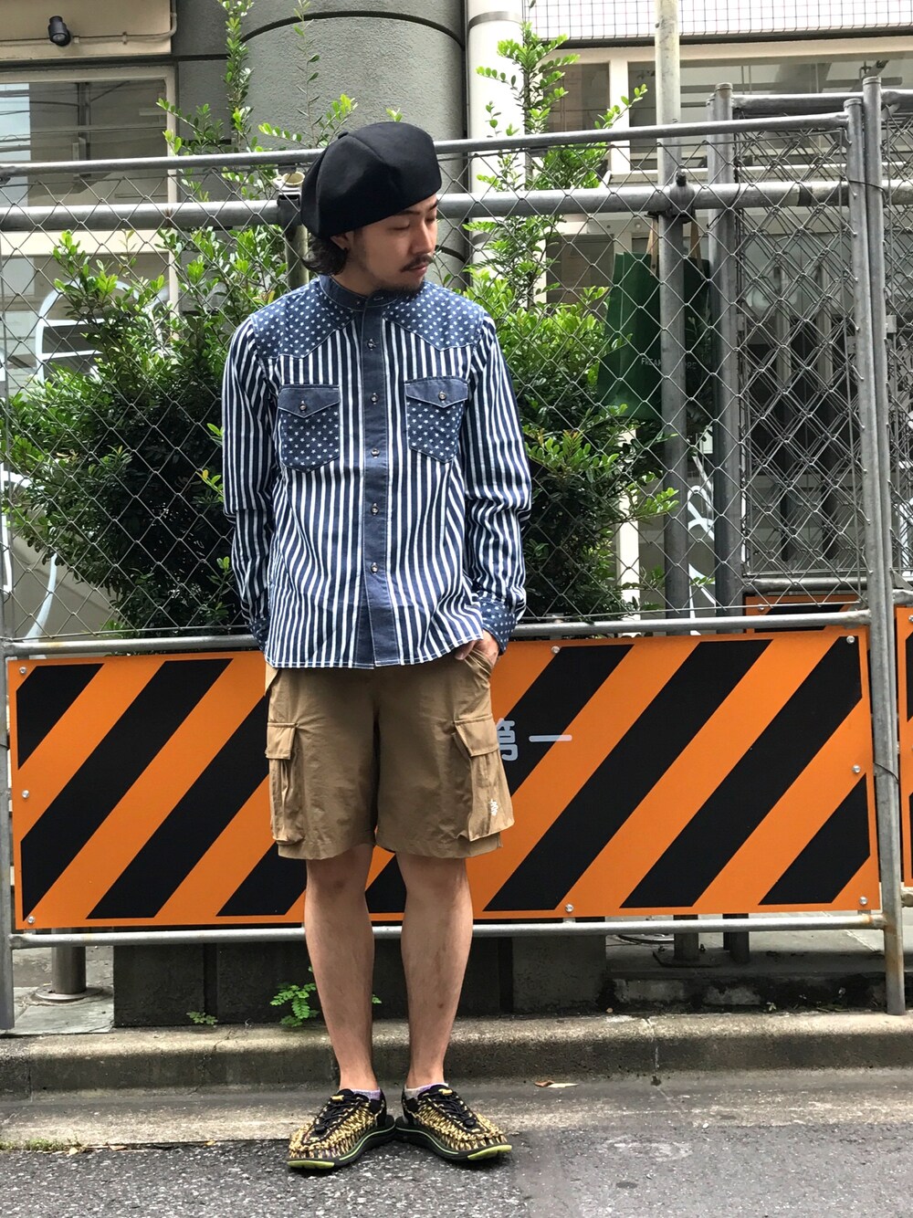 ベージュ系のカーゴパンツ、ブラック系のハンチング/ベレー帽を着用したメンズの夏コーディネートの1枚目の写真