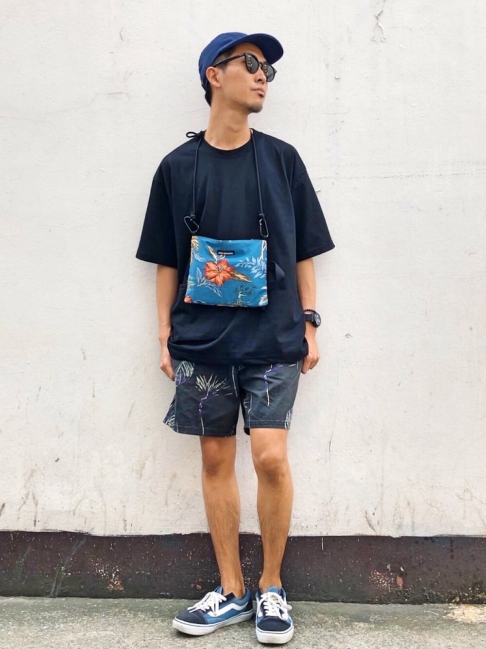 ブラック系のパンツ、ブラック系のTシャツ/カットソー、ブルー系のスニーカーを着用したメンズの冬コーディネートの1枚目の写真