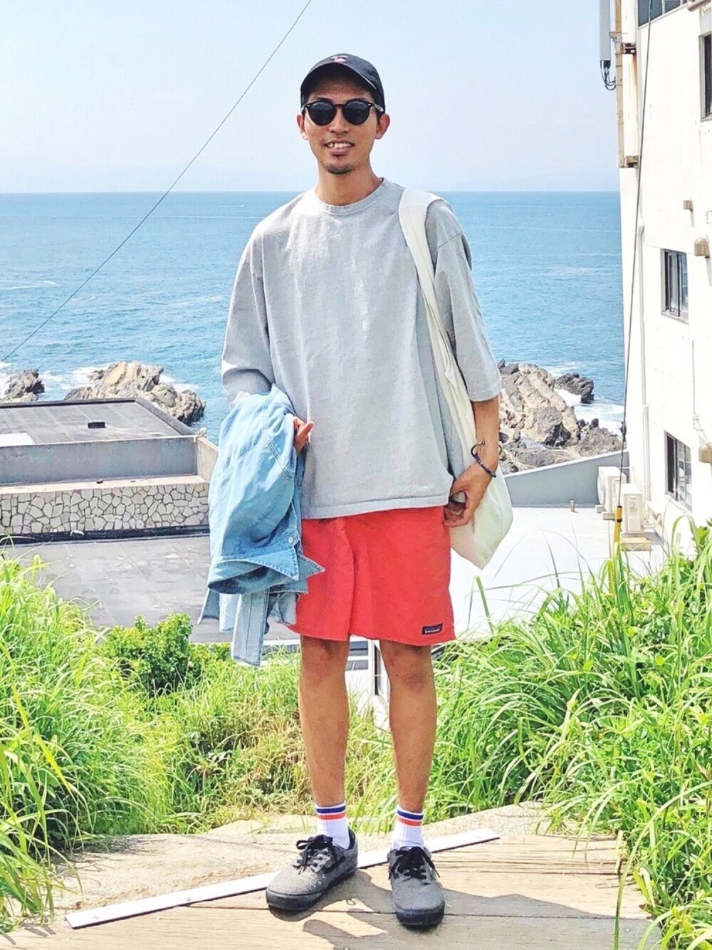 グレー系のTシャツ/カットソー、ピンク系のパンツ、グレー系のスニーカーを着用したメンズの春コーディネートの1枚目の写真