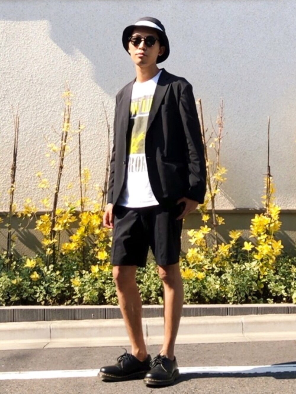 ブラック系のテーラードジャケット、ホワイト系のTシャツ/カットソー、ブラック系のパンツを着用したメンズの春コーディネートの1枚目の写真