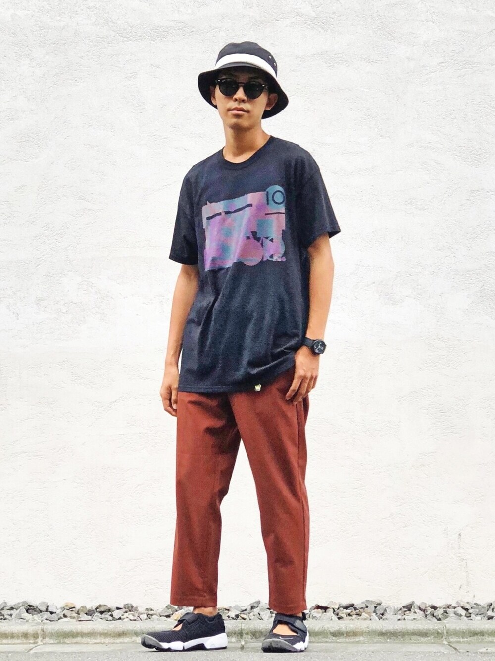ブラック系のTシャツ/カットソー、ブラウン系のパンツ、ブラック系のスニーカーを着用したメンズの夏コーディネートの1枚目の写真