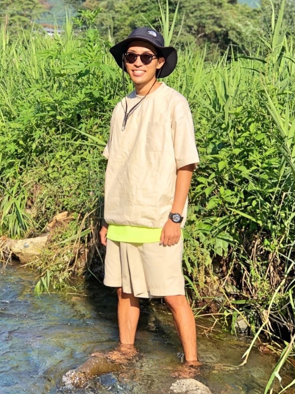 ホワイト系のシャツ/ブラウス、イエロー系のタンクトップ、ベージュ系のパンツを着用したメンズの夏コーディネートの1枚目の写真