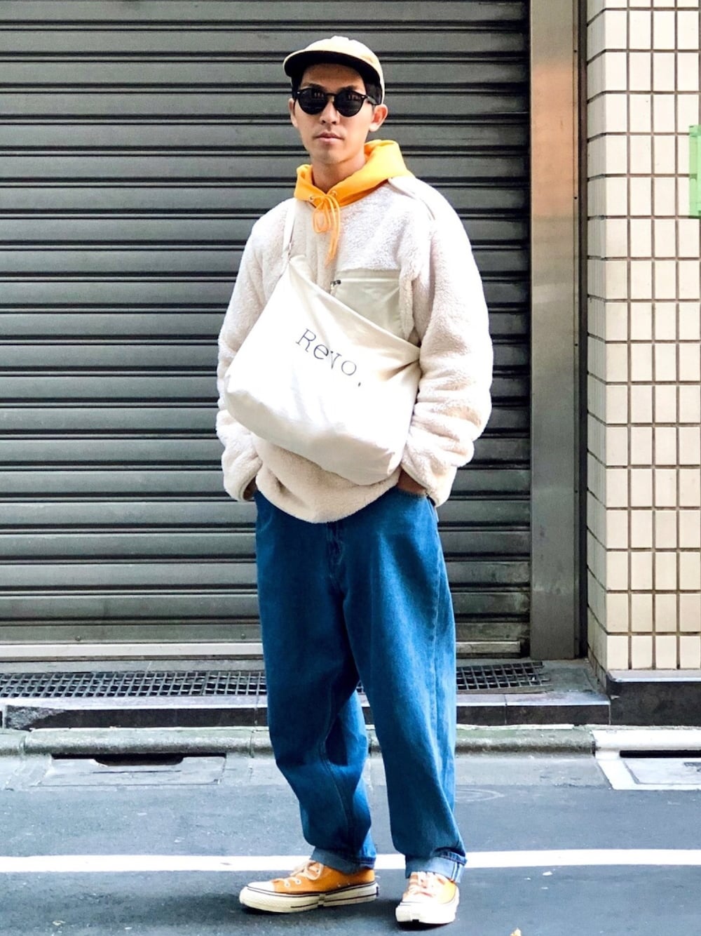 ホワイト系のTシャツ/カットソー、イエロー系のパーカー、ブルー系のデニムパンツを着用したメンズの秋コーディネートの1枚目の写真