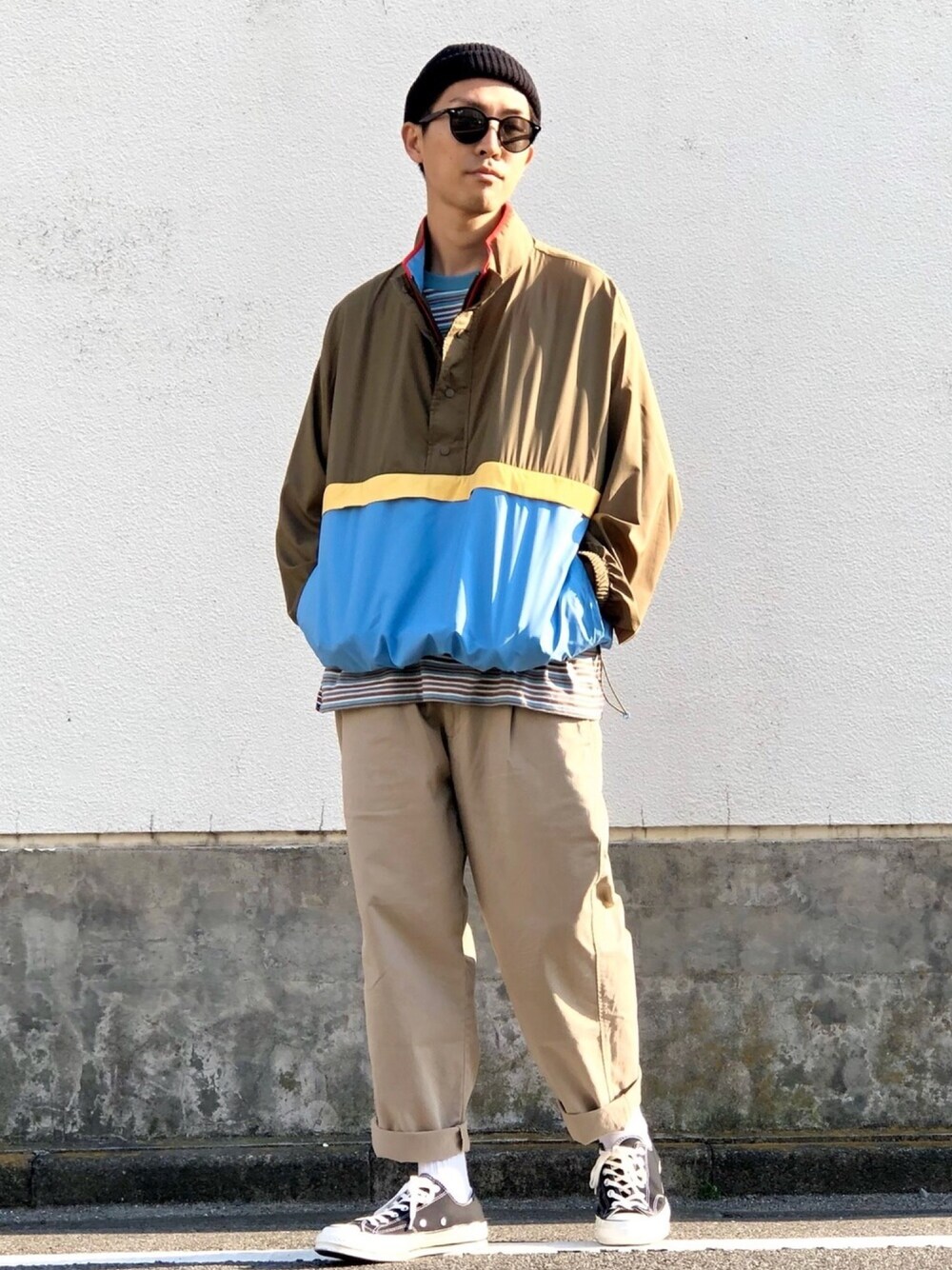 グリーン系のブルゾン、ブルー系のTシャツ/カットソー、ベージュ系のチノパンツを着用したメンズの春コーディネートの1枚目の写真