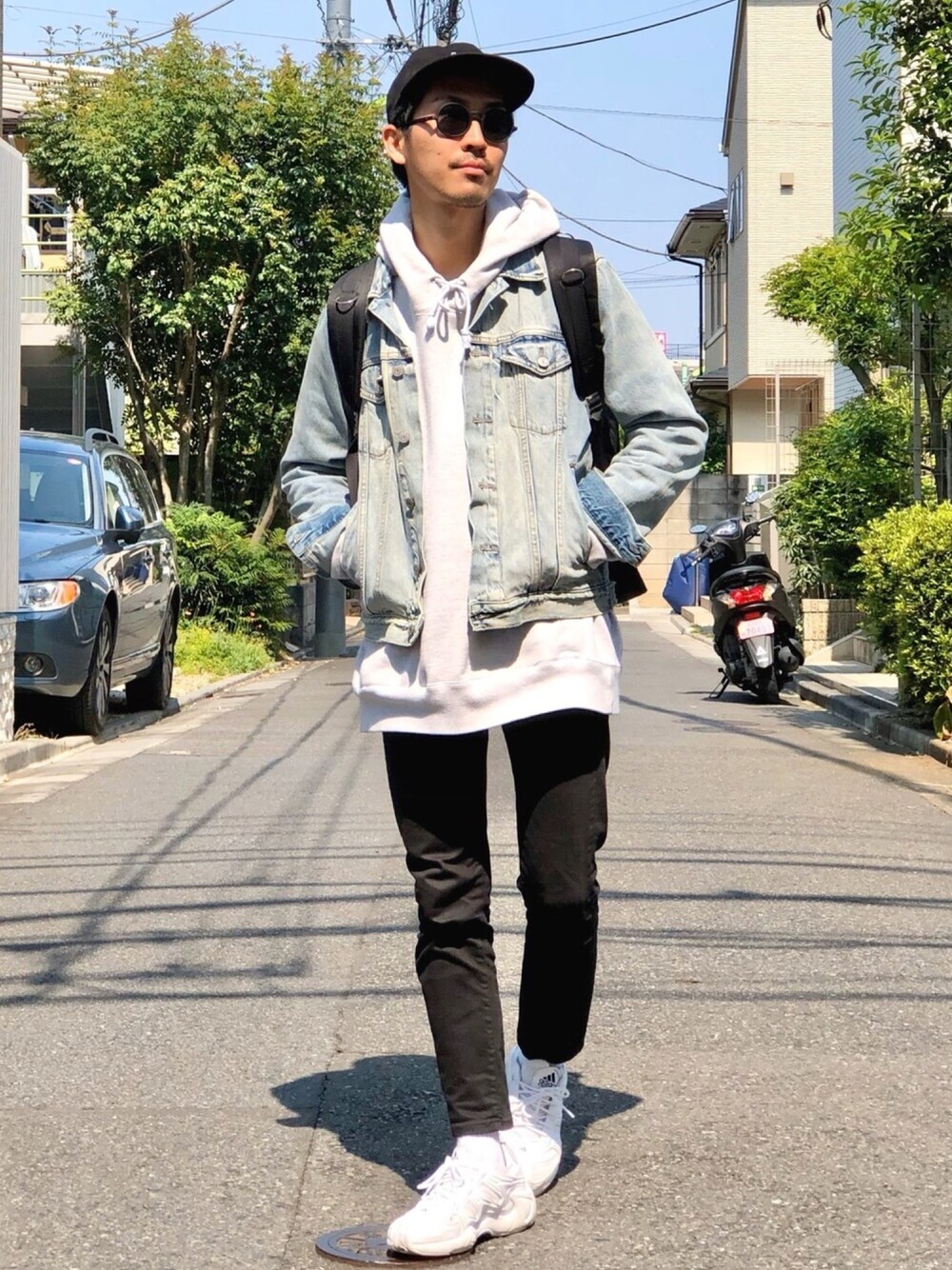ブルー系のデニムジャケット、グレー系のパーカー、ブラック系のチノパンツを着用したメンズの春コーディネートの1枚目の写真