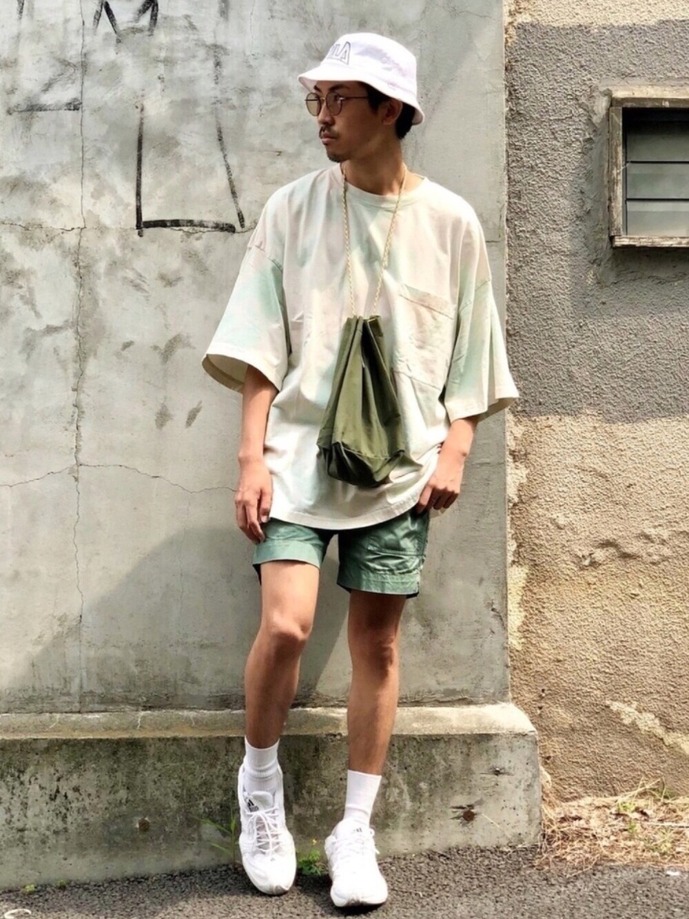 グリーン系のTシャツ/カットソー、グリーン系のカーゴパンツ、ホワイト系のスニーカーを着用したメンズの夏コーディネートの1枚目の写真