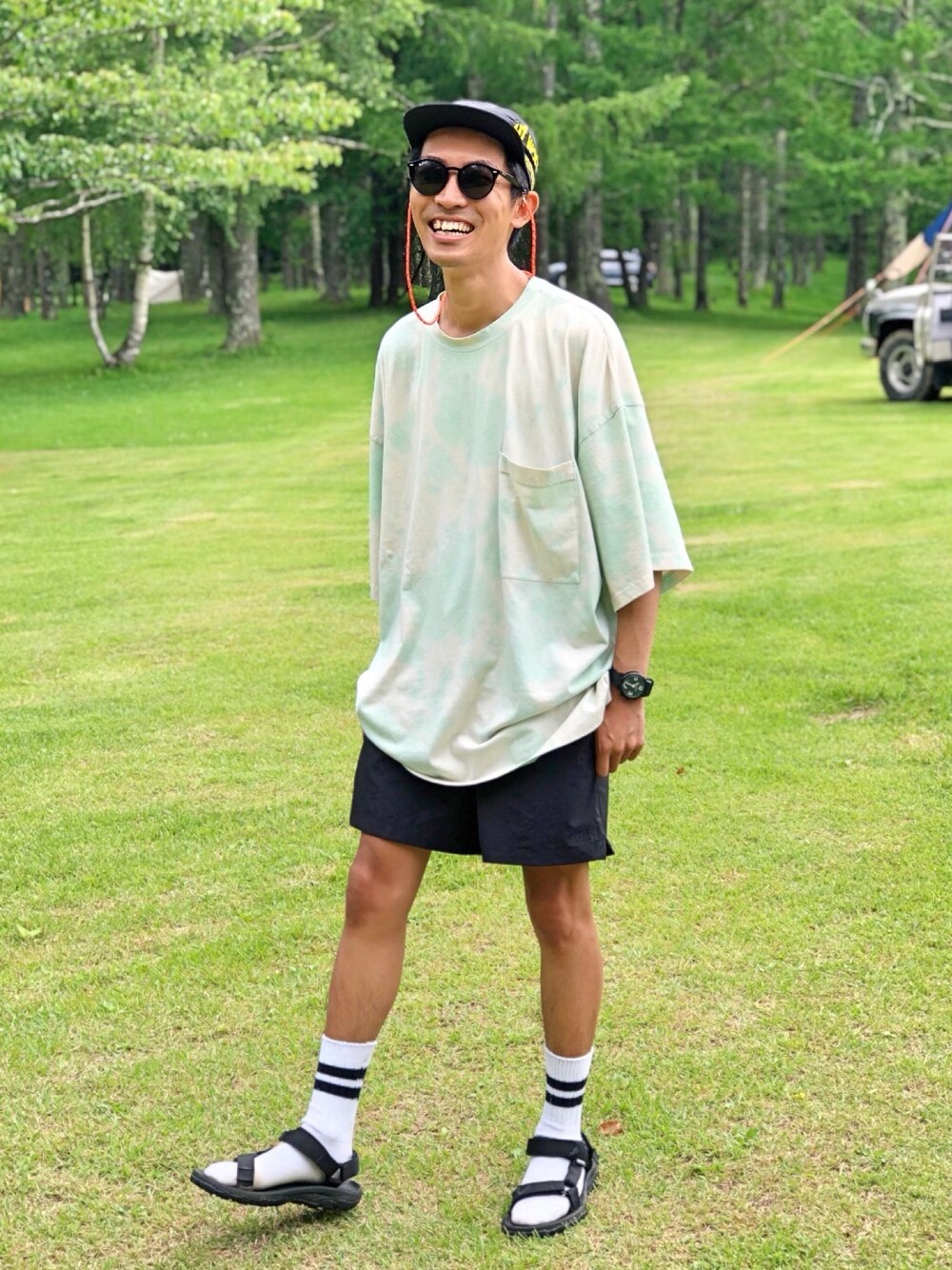 グリーン系のTシャツ/カットソー、ブラック系のその他パンツ、ブラック系のサンダルを着用したメンズの夏コーディネートの1枚目の写真