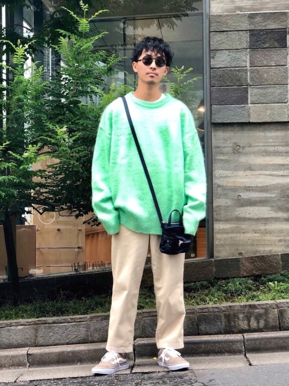 グリーン系のニット/セーター、ホワイト系のパンツ、ベージュ系のスニーカーを着用したメンズの秋コーディネートの1枚目の写真