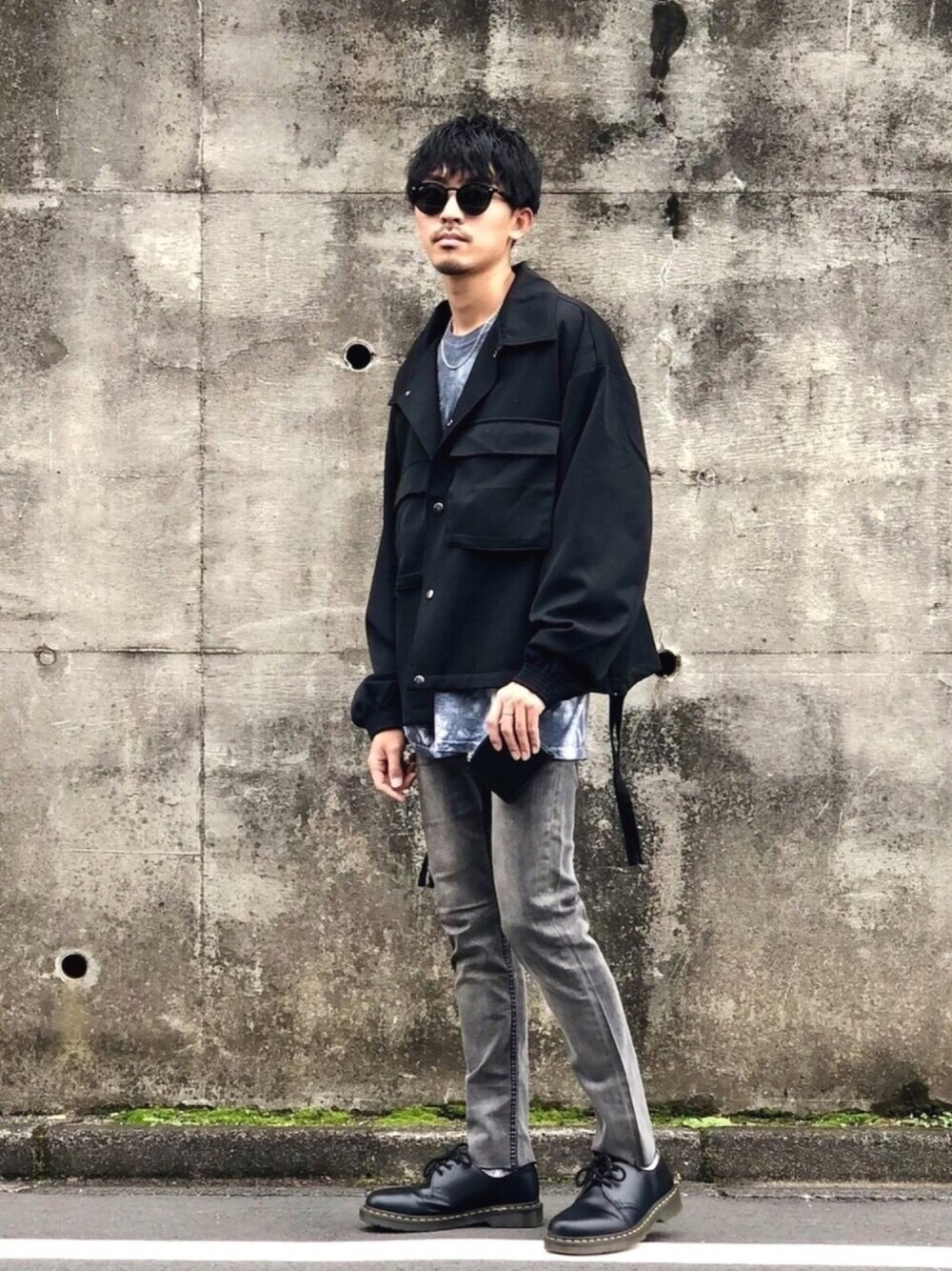 ブラック系のブルゾン、ブラック系のTシャツ/カットソー、グレー系のデニムパンツを着用したメンズの秋コーディネートの1枚目の写真