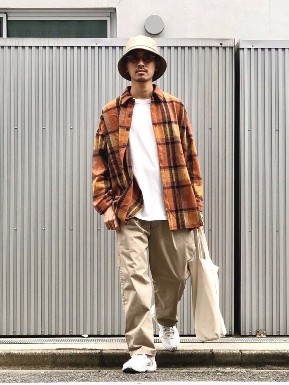 イエロー系のブルゾン、ホワイト系のTシャツ/カットソー、ベージュ系のチノパンツを着用したメンズの秋コーディネートの1枚目の写真